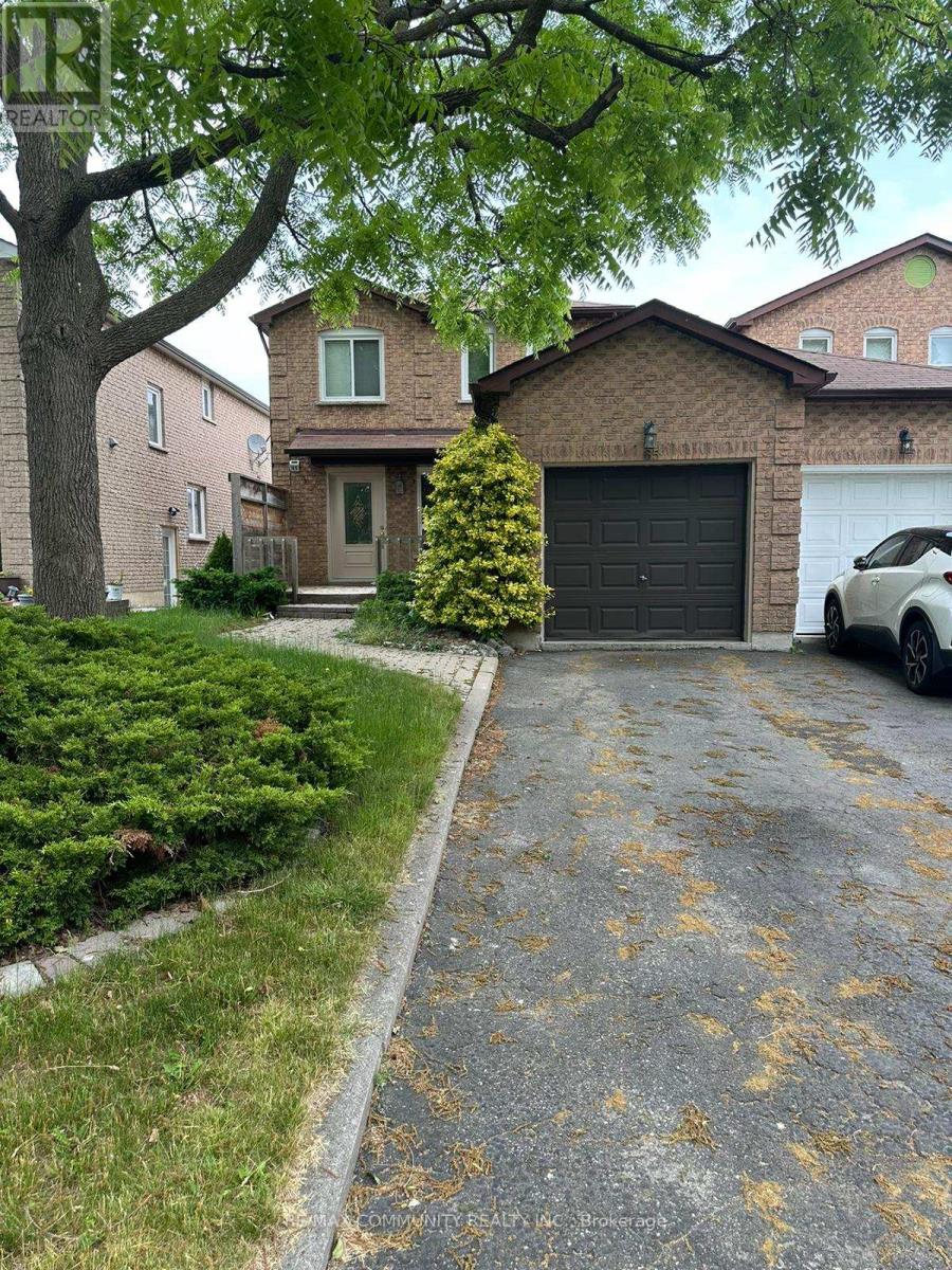 A house with a driveway and a tree in front of it.