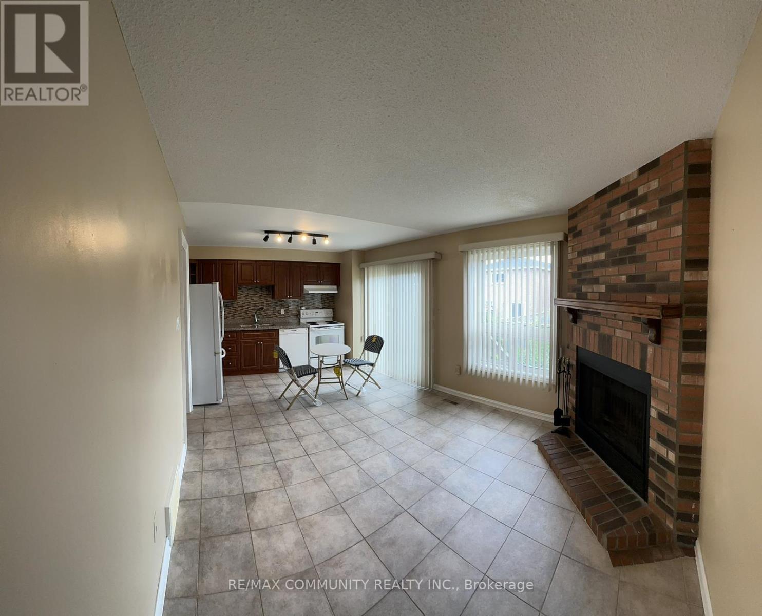 A living room with a fireplace and a dining table.