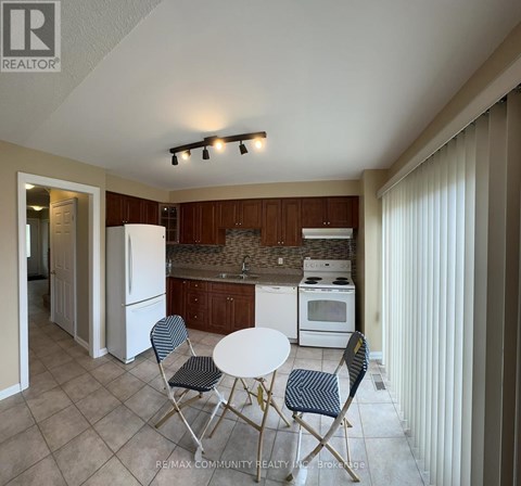 A kitchen with a table and chairs in the foreground.