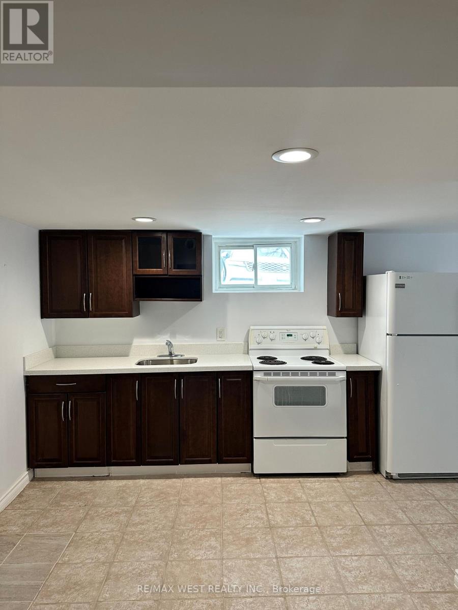 A white stove and refrigerator in a kitchen with brown cabinets.