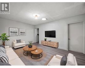 A living room with a white couch, a coffee table, and a flat-screen TV.