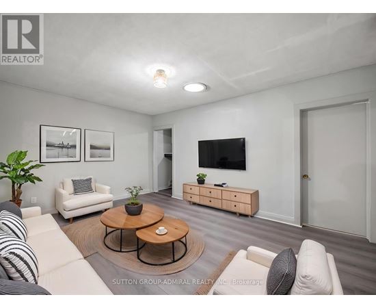 A living room with a white couch, a coffee table, and a flat-screen TV.
