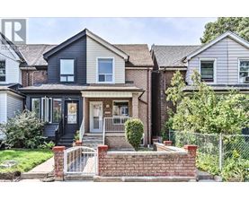 A house with a black front door and a brick wall in front.