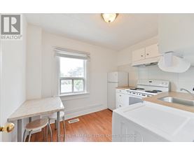 A small white kitchen with a table and chairs.