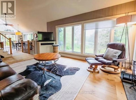 A living room with a brown leather couch and a wooden coffee table.