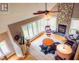 A living room with a fan, a couch, and a table.