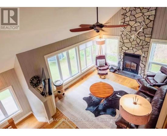 A living room with a fan, a couch, and a table.