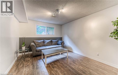 A living room with a grey couch and a glass end table.