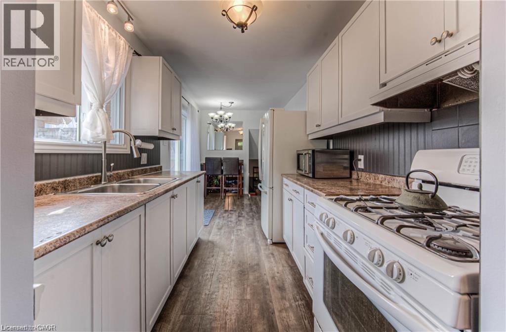 A kitchen with white cabinets and a stove top oven.