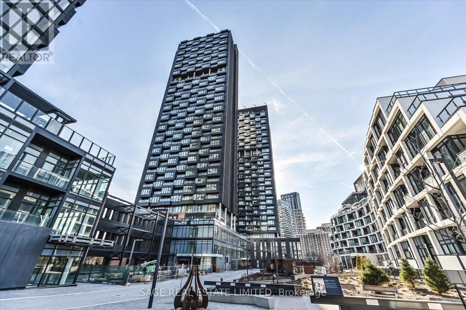 A modern building with a glass facade stands tall in a cityscape.