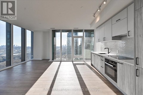 A modern kitchen with white cabinets and a view of the city.