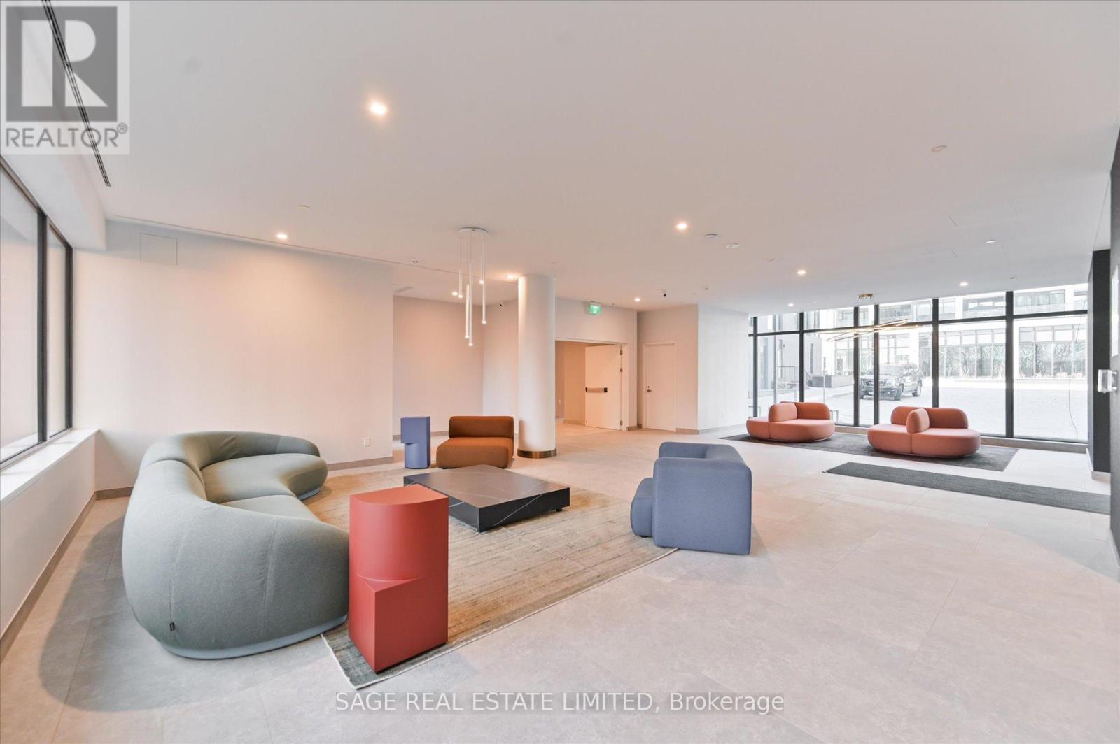 A spacious living room with a variety of seating options and a large window.