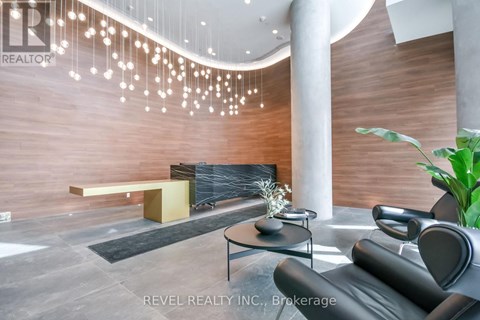 A modern living room with a black leather sofa and a wooden bench.