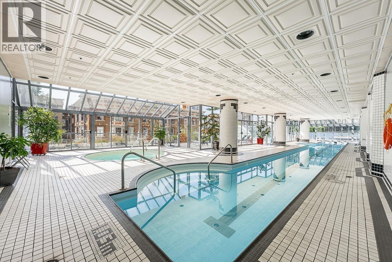 A large indoor swimming pool with a glass ceiling.
