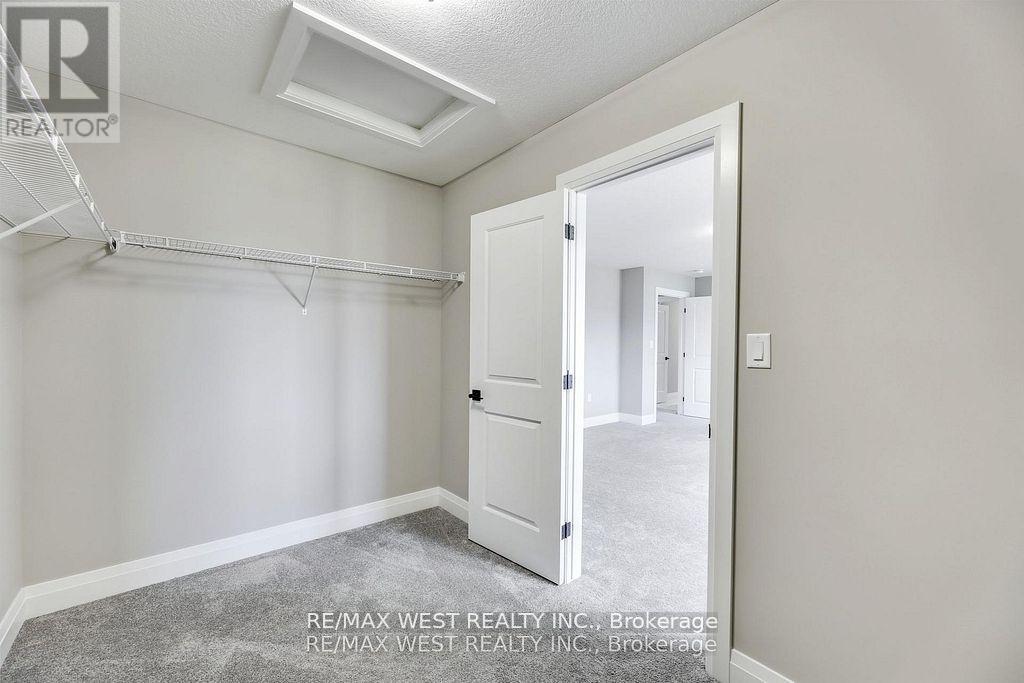 A bedroom with a slanted ceiling and a white door.