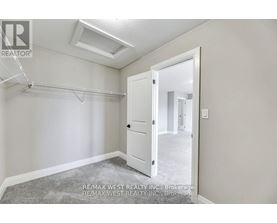A bedroom with a slanted ceiling and a white door.