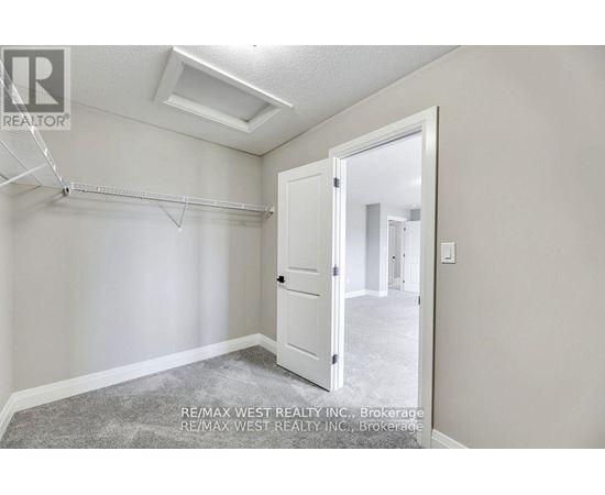 A bedroom with a slanted ceiling and a white door.