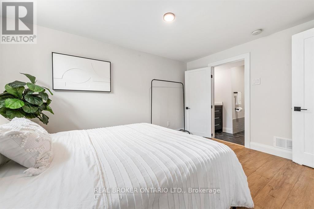 A bedroom with a large bed and a plant on the side table.