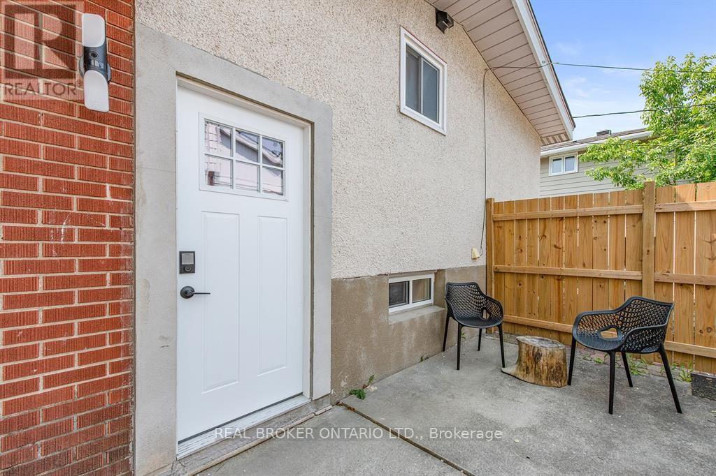 A small house with a white door and a small patio with two chairs.