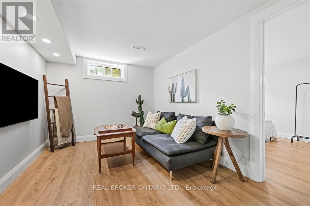 A living room with a grey couch, a wooden table, and a painting on the wall.