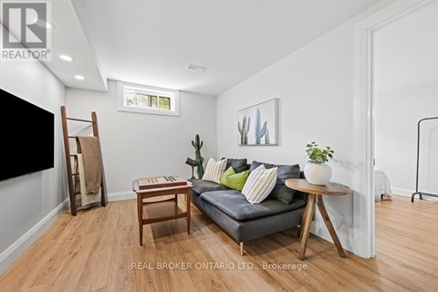 A living room with a grey couch, a wooden table, and a painting on the wall.