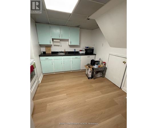 A kitchen with light wood floors and white walls.