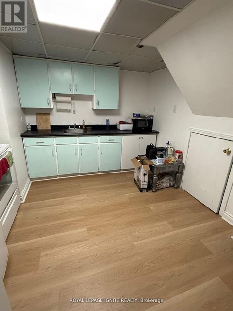 A kitchen with light wood floors and white walls.
