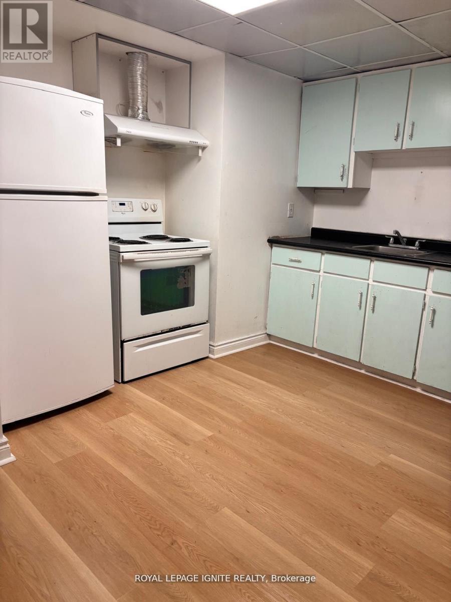 A kitchen with white appliances and wooden floors.