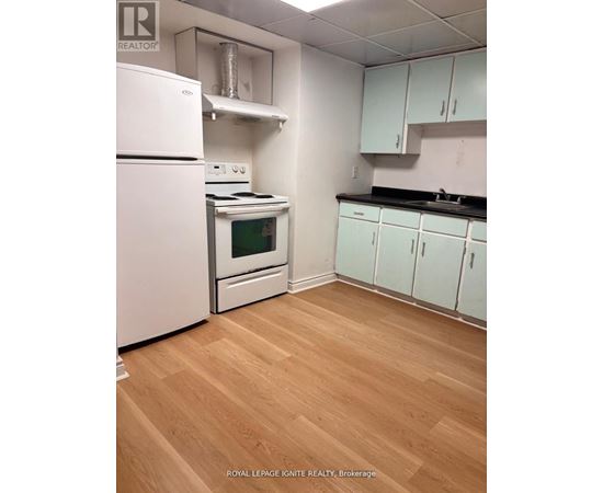 A kitchen with white appliances and wooden floors.