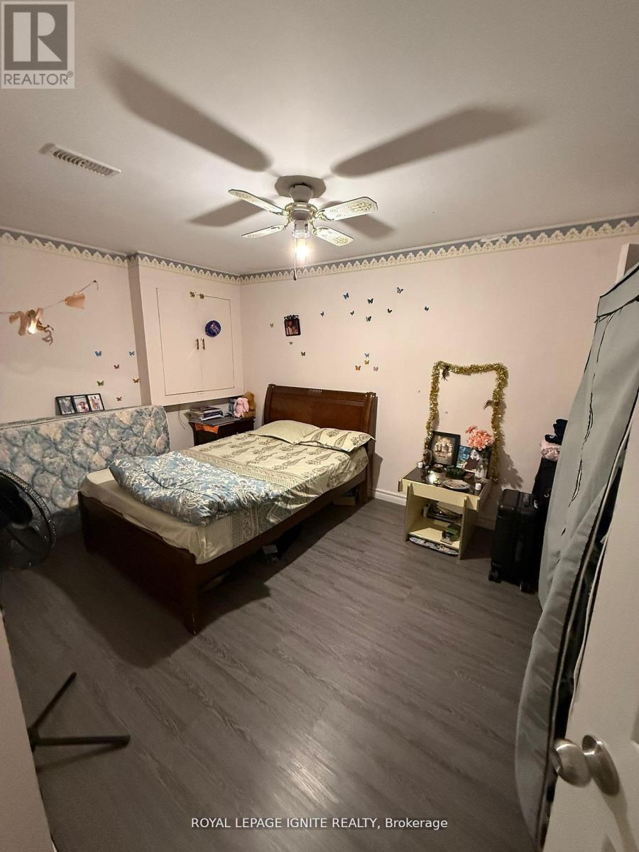 A bedroom with a bed, a fan, and a dresser.