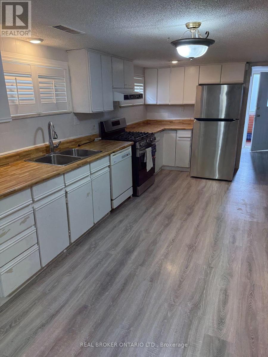 A kitchen with white cabinets and a wooden countertop.