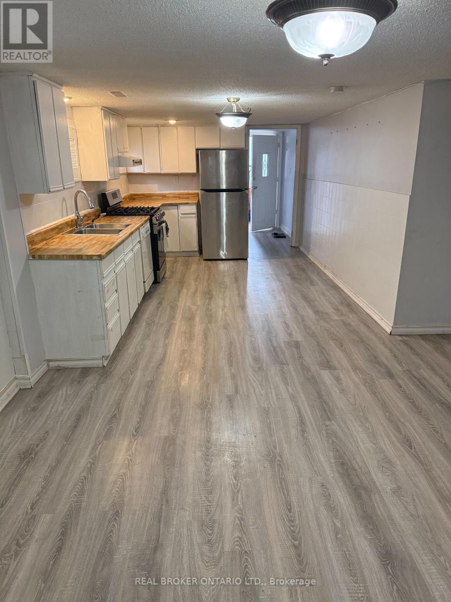 A kitchen with a wooden floor and white cabinets.