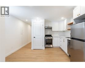 A kitchen with white cabinets and a black refrigerator.