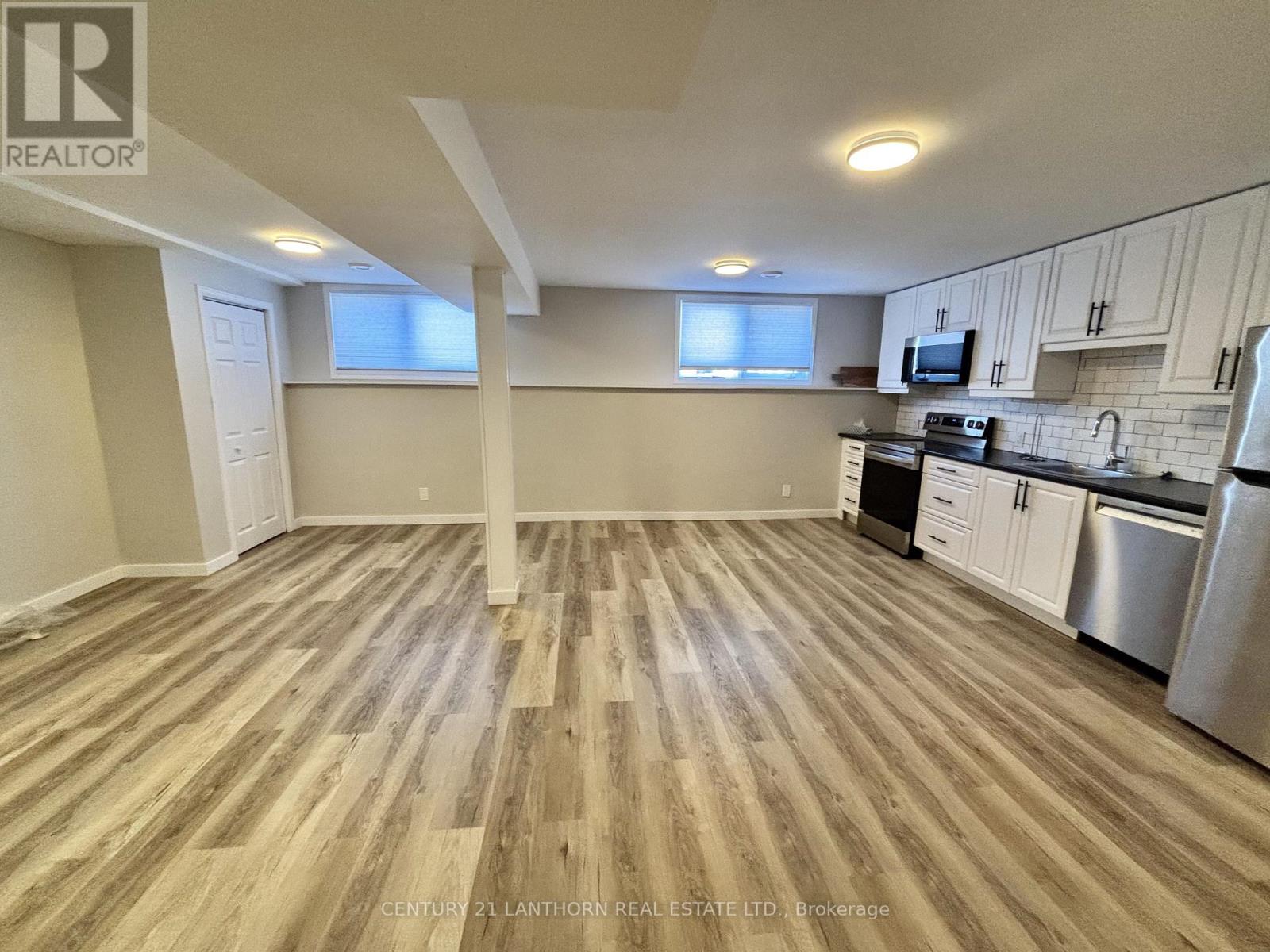 A kitchen with wooden floors and stainless steel appliances.