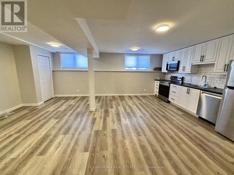 A kitchen with wooden floors and stainless steel appliances.