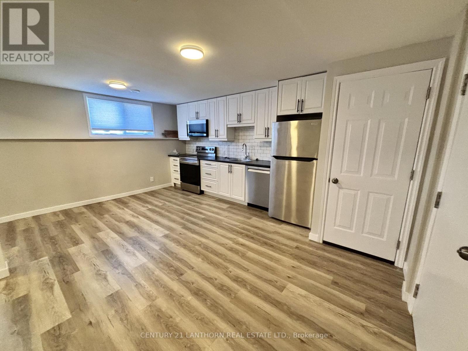 A kitchen with wooden floors and white cabinets.