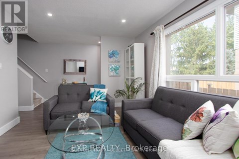 A living room with a grey couch and a glass coffee table.