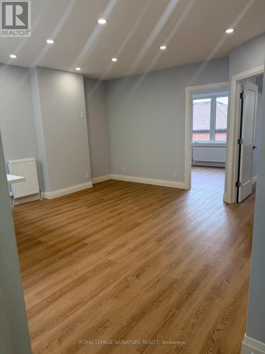 A room with wooden flooring and white walls.