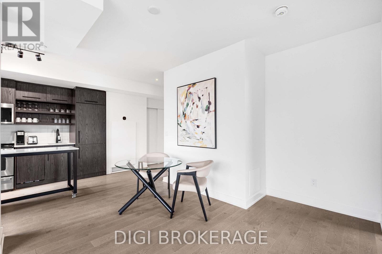 A modern dining room with a glass table and chairs.