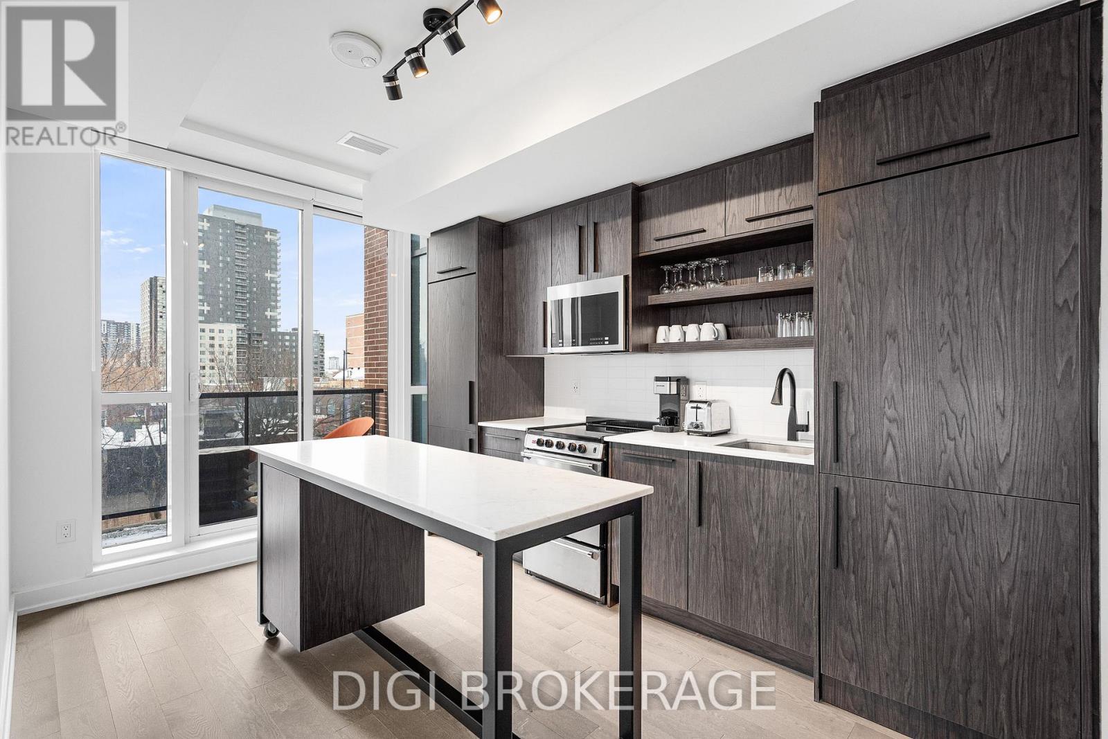 A modern kitchen with dark wood cabinets and a white island.