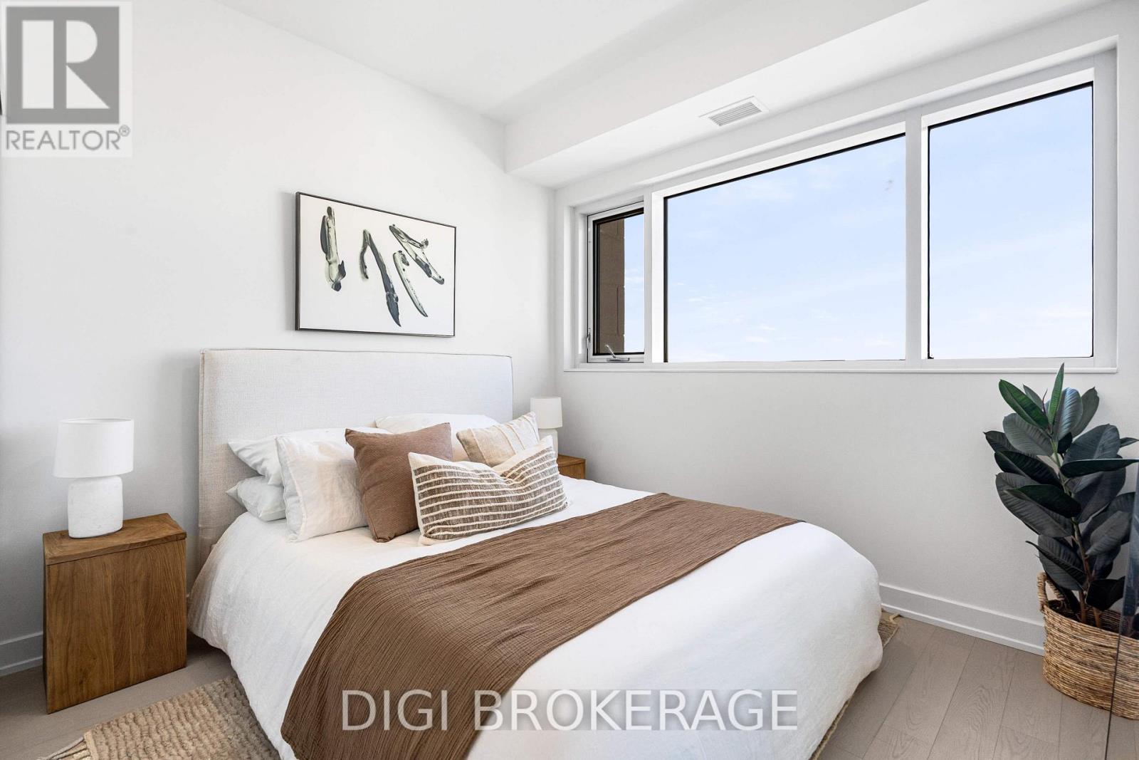 A bedroom with a large bed and a painting on the wall.