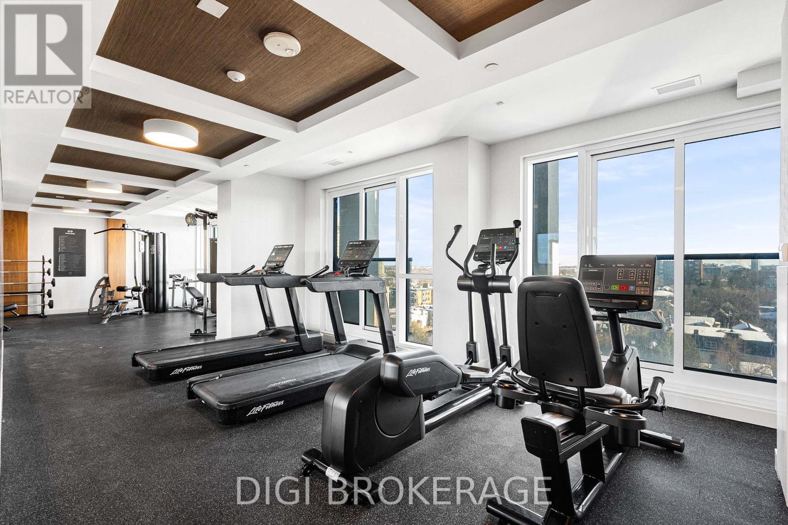A well-equipped gym with treadmills, exercise bikes, and a digital display.