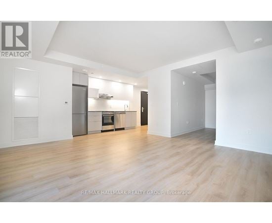A spacious, empty room with wooden floors and white walls.