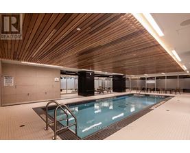 A large indoor swimming pool with a wooden ceiling.