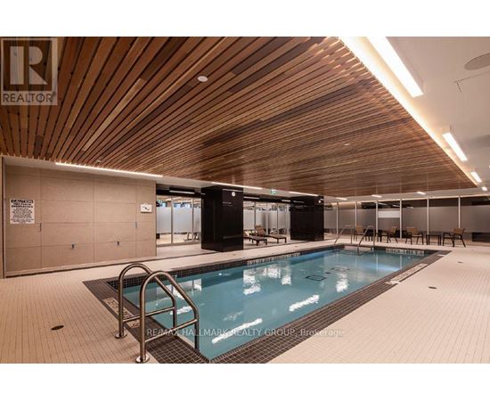 A large indoor swimming pool with a wooden ceiling.