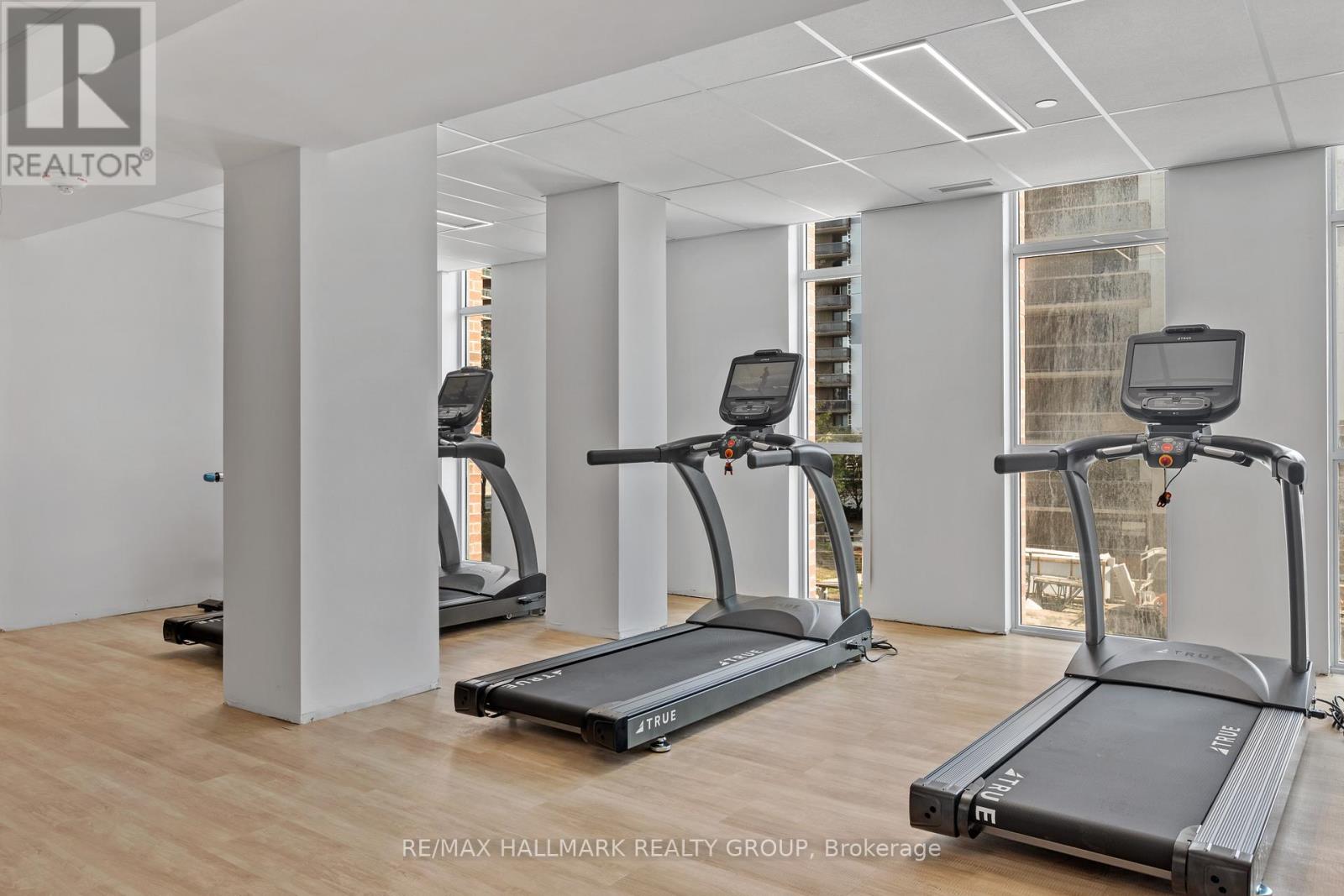 A gym with treadmills and a RE/MAX logo.