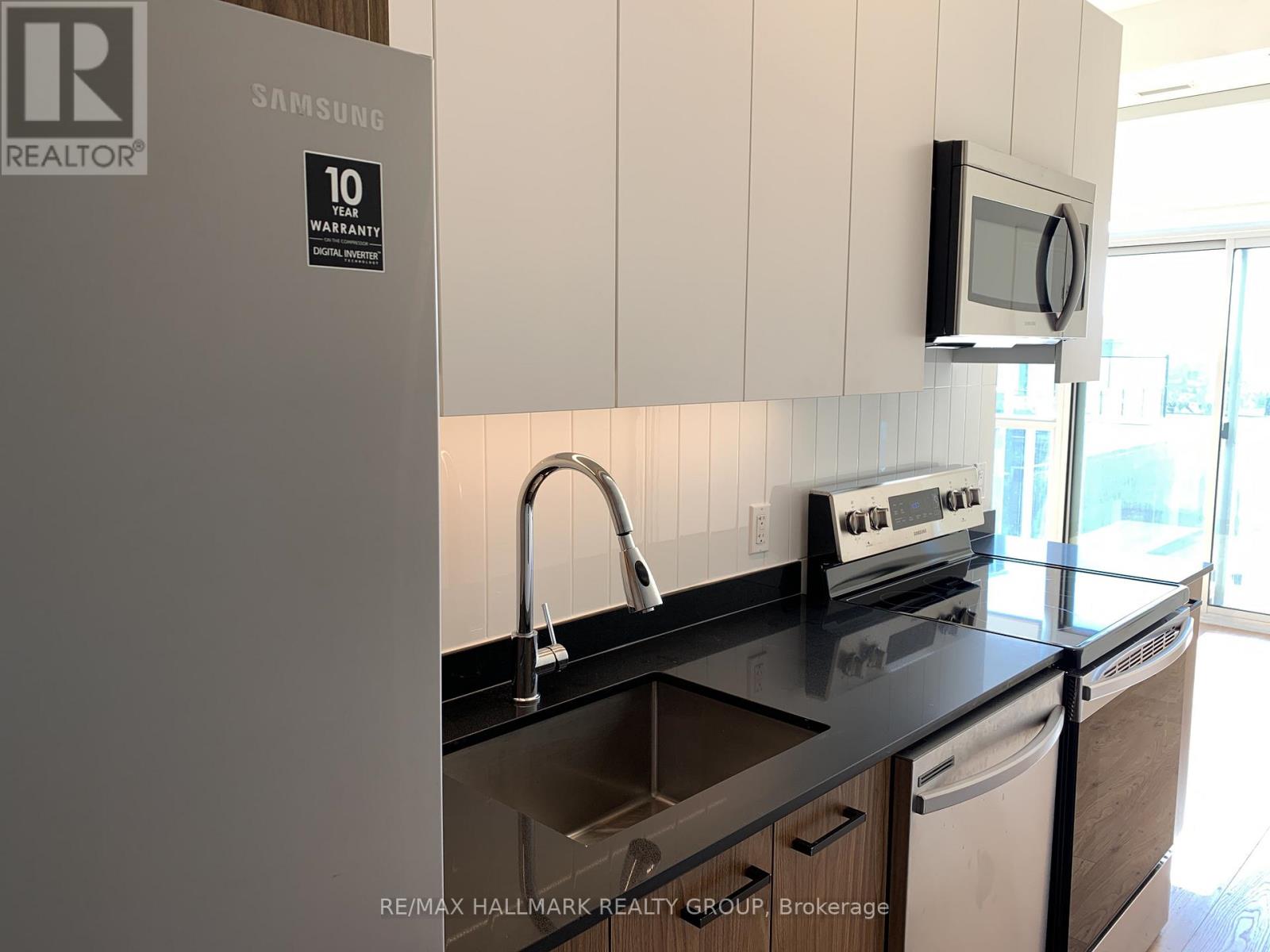 A kitchen with a Samsung fridge and a microwave oven.