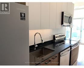 A kitchen with a Samsung fridge and a microwave oven.