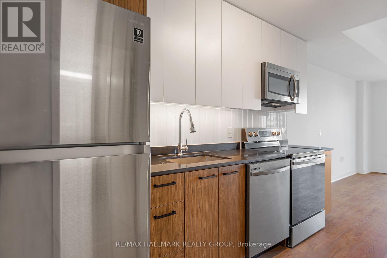 A kitchen with a refrigerator and a microwave.