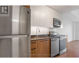 A kitchen with a refrigerator and a microwave.